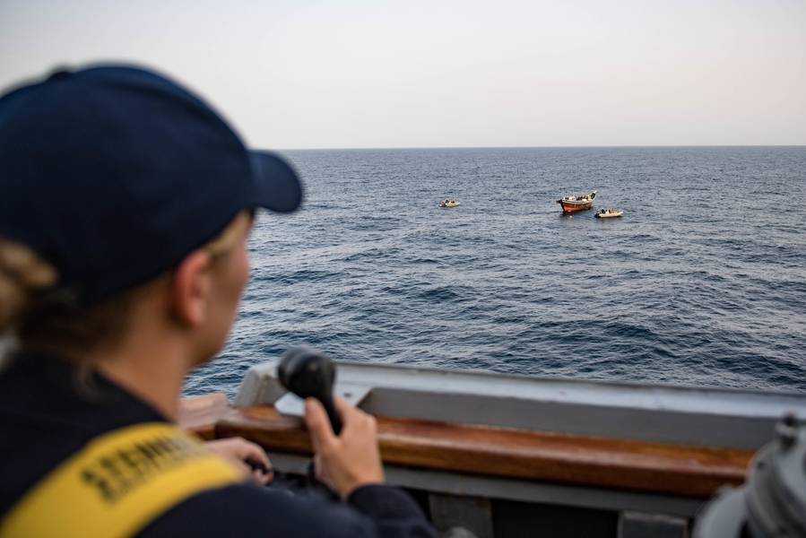 Eine US-Marine-Fähnrich Conn aus dem Brückenflügel der USS Jason Dunham (DDG 109) als das Schiff Besuch, Bord-, Such-und Beschlagnahme-Team inspiziert eine Dhow. (US Navy Foto von Jonathan Clay)