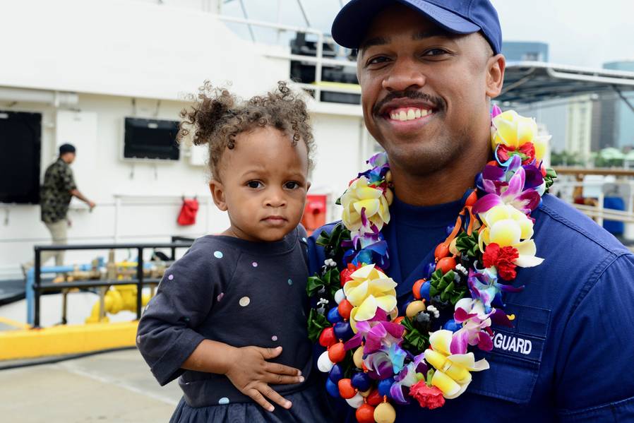 Jg. Joshua Martin, leitender Angestellter der Küstenwache Cutter Joseph Gerczak, hält seine Tochter nach der Ankunft des Kutters Honolulu am 4. Februar 2018 (USCG Foto von Sara Muir)