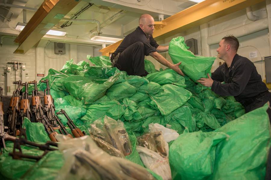 Los marineros de la armada estadounidense apilan un alijo de rifles automáticos AK-47 a bordo del destructor de misiles guiados USS Jason Dunham (DDG 109). (Foto de la Marina de los EE. UU. Por Jonathan Clay)