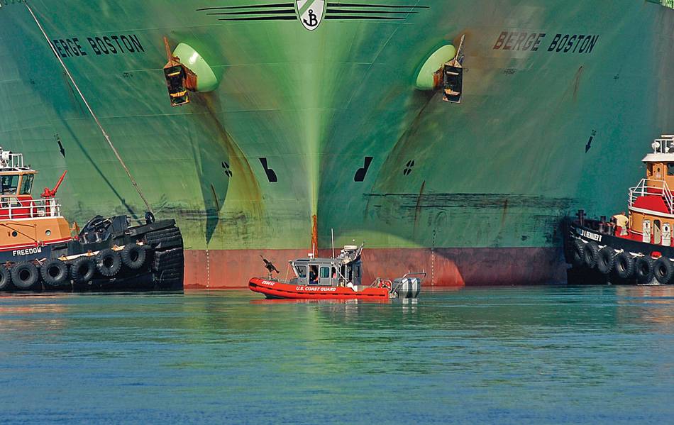 Mientras proporciona un perímetro de seguridad, un bote de respuesta de 25 pies de la Guardia Costera está flanqueado por dos remolcadores cuando el petrolero de gas natural líquido Berge Boston está amarrado al muelle en una instalación de GNL aquí. Foto de USCG por PA2 Luke Pinneo