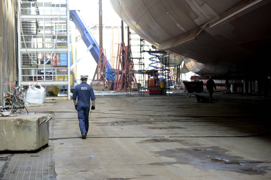 Lt. jg Ryan Thomas, ein Marineinspektor am Coast Guard Sector Delaware Bay, läuft unter dem Kaimana Hila, einem 850 Fuß langen Containerschiff, das in Philadelphia Shipyards am 4. Oktober 2018 gebaut wird. Der Kaimana Hila und der Daniel K. Inouye sind die zwei größten Containerschiffe, die jemals in den USA gebaut wurden (Coast Guard Foto von Seth Johnson)