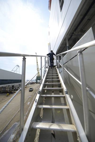 Lt. jg Ryan Thomas, ein Marineinspektor am Coast Guard Sector Delaware, geht die Gangway des Daniel K. Inouye hinauf, ein Containerschiff, das in Philadelphia Shipyards gebaut wird. (Küstenwache Foto von Seth Johnson)