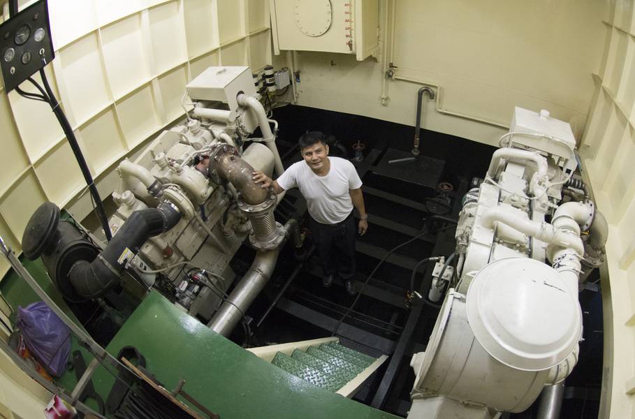 El capitán del puerto, Mitr Daiwong, de pie en la sala de máquinas del puerto con uno de los motores principales Cummins KTA19-M de 600 HP. El grupo electrógeno NT855 de 150 kW está a su izquierda. (Crédito de la foto: Haig-Brown / Cummins Marine)