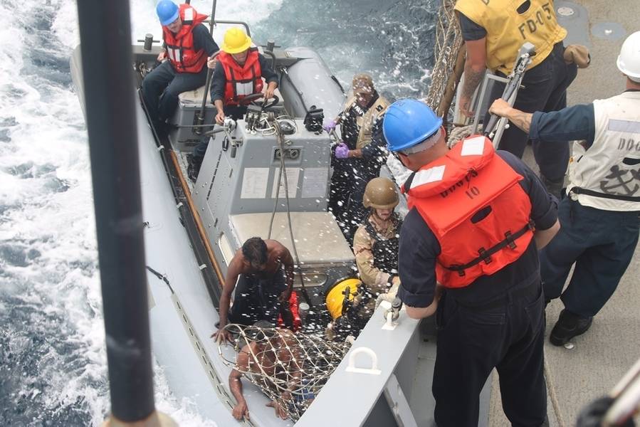 Os marinheiros trazem o pescador do Sri Lanka a bordo do destróier de mísseis guiados da classe Arleigh Burke USS Decatur (DDG 73) usando um barco inflável de casco rígido (RHIB) depois que o navio parou para prestar assistência a uma embarcação de pesca presa. (Foto da Marinha dos EUA)