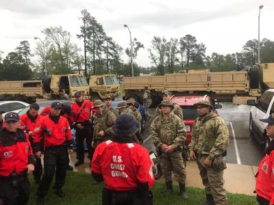 海上保安庁の乗組員は、2018年9月16日、ノースカロライナ州のハリケーンフィレンツェに対応して救助活動を行う前に、戦術について話し合っています。沿岸警備隊は被災地の州や地方の機関と協力しています。画像：USCG）