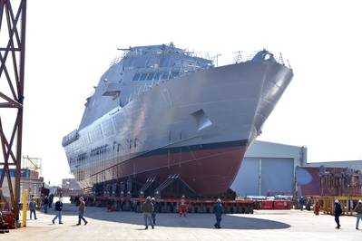 Das zukünftige Küstenkampfschiff USS Indianapolis (LCS 17) wird von einer Indoor-Produktionsstätte in Marinette, Wisconsin, zu den Abschussrampen verlegt, um den Start am 14. April in den Menomenee River vorzubereiten. (US Navy Foto mit freundlicher Genehmigung von Marinette Marine von Val Ihde)