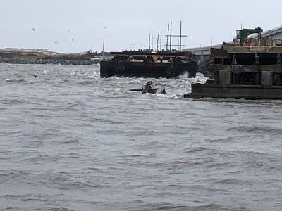 Der halb untergetauchte Schlepper Miss Bonnie sitzt im Wasser, nachdem er die alte Bonner-Brücke in Oregon Inlet, North Carolina, angefahren hat. (US Coast Guard Foto mit freundlicher Genehmigung der Coast Guard Station Oregon Inlet)