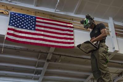 Ein US-Marine verwendet ein tragbares Wartungshilfsmittel an Bord des Flugzeugträgers der Nimitz-Klasse USS Abraham Lincoln (CVN 72) im Einsatzgebiet der 5. US-Flotte. (Foto der US Navy)