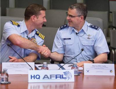 US-Küstenwache Capt. Greg Rothrock, kommandierender Offizier des Coast Guard Research and Development Centre, und Generalmajor William Cooley, Luftwaffenforschungslaborator, schütteln sich am 12. April 2018 auf dem Luftwaffenstützpunkt Wright-Patterson in Ohio nachdem sie ein Memorandum of Understanding zwischen ihren beiden Organisationen unterzeichnet hatten. Die Vereinbarung ermöglicht es USCG RDC und AFRL, bei Aufgaben von gegenseitigem Nutzen zusammenzuarbeiten. (US Air Force Foto von RJ Oriez)