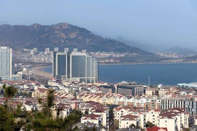 Uma vista de alto ângulo de Fushan, Qingdao, com o litoral e os edifícios à beira-mar à distância. Tirada em Qingdao, Shandong, China. Por Xiaohan Zhou