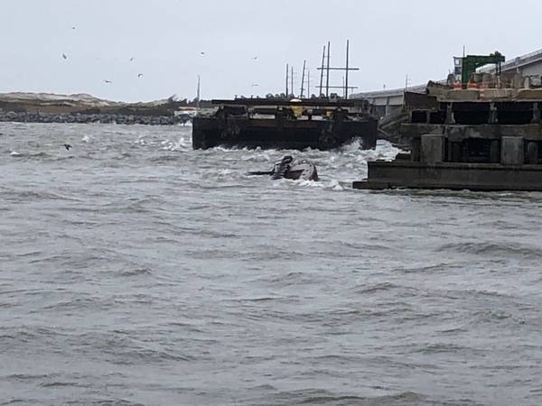 Der halb untergetauchte Schlepper Miss Bonnie sitzt im Wasser, nachdem er die alte Bonner-Brücke in Oregon Inlet, North Carolina, angefahren hat. (US Coast Guard Foto mit freundlicher Genehmigung der Coast Guard Station Oregon Inlet)