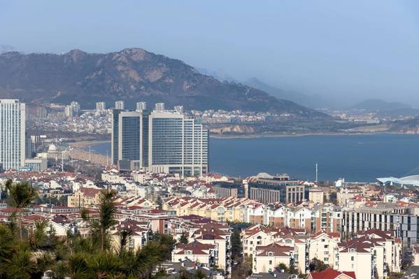 Eine Vogelperspektive auf Fushan, Qingdao, mit der Küste und den am Meer gelegenen Gebäuden in der Ferne. Aufgenommen in Qingdao, Shandong, China. Von Xiaohan Zhou