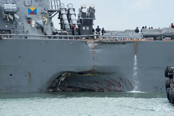 Schäden an der Backbordseite sind sichtbar, da der Lenkwaffenzerstörer USS John S. McCain (DDG 56) nach einer Kollision mit dem Handelsschiff Alnic MC nach Changi Naval Base in der Republik Singapur steuert, während er östlich der Straße von Malakka und Singapur unterwegs ist . Erhebliche Schäden am Rumpf führten zu Überflutungen in nahegelegene Abteilungen, einschließlich Besatzungsmitgliedern, Maschinen und Kommunikationsräumen. Schadensbegrenzungsbemühungen der Besatzung verhinderten weitere Überschwemmungen. (US Navy Foto von Mass Communica