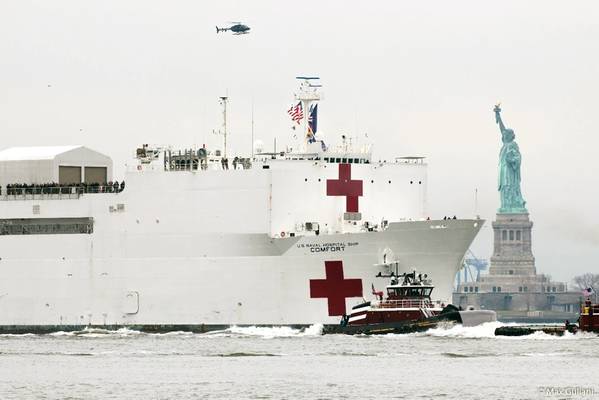 O capitão Brian A. McAllister lidera o caminho para o USNS COMFORT no porto de NY ao passar pela Estátua da Liberdade em 30 de março de 2020. (Crédito da foto: Max Guliani)