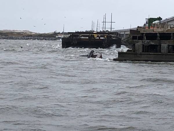 O rebocador semi-submerso Miss Bonnie fica na água depois de passar pela Old Bonner Bridge em Oregon Inlet, Carolina do Norte. (Foto da Guarda Costeira dos EUA cortesia da Estação da Guarda Costeira Oregon Inlet)