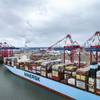 A Maersk boxship alongside in port, working cargo. (c) Maersk