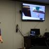 Computer Engineer Daniel Stith shows how to use the hands-free headset for the virtual reality simulation. (Photo: U.S. Navy)