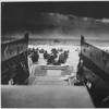 U.S. Soldiers disembark a landing craft under heavy fire off the coast of Normandy, France, June 6, 1944. (Photo Credit: National Archives U.S. Coast Guard Collection)