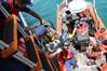 A crewmember aboard the Coast Guard Cutter Valiant lowers a child to a boatcrew during a repatriation off the coast of Haiti, June 16, 2015. Fifty-four Haitian migrants were interdicted south of St. John, Virgin Islands, aboard an overloaded sailing vessel on June 10.  (USCG photo)
