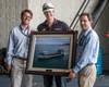 NASSCO Program Manager William McKay and Area Manager Aaron Rockwell present the ship's captain, Jonathan Olmsted, with a photo of the MLP 3 AFSB, USNS Lewis B. Puller. (Photo: NASSCO)