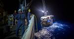 Crew members aboard a NOAA ship in 2016 use a cran