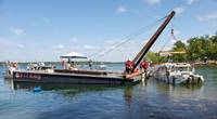 The Coast Guard oversees the removal of Stretch Duck 7 from Table Rock Lake in Branson, Missouri, July 23, 2018. Missouri State Highway Patrol divers rigged the vessel, then a barge crane lifted it to the surface before it was towed to shore and loaded onto a flatbed trailer for transport to a secure facility. (U.S. Coast Guard photo by Lora Ratliff)
