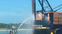 A West Manatee County Fire Department marine unit crew extinguish the fire on a commercial barge after a good Samaritan reported the incident. (U.S. Coast Guard photo)
