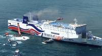 The Caribbean Fantasy’s during the final stage of abandonment, with its starboard anchor down. Gray smoke is coming out of the two funnels, and a Coast Guard helicopter is hovering over the upper deck of the ship. (Photo by U.S. Coast Guard)