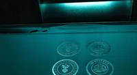 Logos from Newport News Shipbuilding and 3D Systems were fabricated during a demonstration of the new 3-D printer. (Photo by John Whalen/HII)