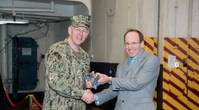 Don Hamadyk, Newport News Shipbuilding's director of research and development, presented the first 3-D printed metal part to Rear Adm. Lorin Selby, Naval Sea Systems Command’s chief engineer and deputy commander for ship design, integration, and naval engineering during a brief ceremony on USS Harry S. Truman (CVN 75). Photo by Matt Hildreth/HII.