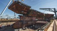 The 780-ton upper bow unit was lowered into the dry dock on Wednesday and placed on the aircraft carrier John F. Kennedy (CVN 79). (Photo by Ashley Cowan/HII)