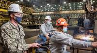 Erika Lynd, Ingalls burner workleaderman, cuts steel into patterns using the Avenger IV plasma cutter, signifying 100 tons of steel cut and start of fabrication for the destroyer Jeremiah Denton (DDG 129). Observing the milestone are U.S. Navy Cmdr. Sean Doherty, DDG program manager’s representative, and Ben Barnett, Ingalls Shipbuilding’s DDG 129 ship program manager. Photo by Derek Fountain/HII