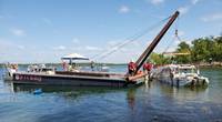 The Coast Guard oversees the removal of Stretch Duck 7 from Table Rock Lake in Branson, Missouri, July 23, 2018. Missouri State Highway Patrol divers rigged the vessel, then a barge crane lifted it to the surface before it was towed to shore and loaded onto a flatbed trailer for transport to a secure facility. U.S. Coast Guard photo by Petty Officer 3rd Class Lora Ratliff