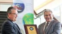 Left to right: Craig McLean of NOAA presents Fugro’s Edward Saade with a commemorative plaque in formal commendation of the company’s leadership in advancing global ocean mapping (Photo: Fugro)