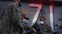 U.S. Sailors fold the American flag after evening colors on the flight deck of the aircraft carrier USS Theodore Roosevelt (CVN 71) April 24, 2020. (U.S. Navy photo by Kaylianna Genier)