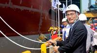 Takaaki Anraku, President Kokusai Cable Ship Company Ltd of Japan, cutting the rope to break the milk pot against the vessel’s hull. Photo: Colombo Dockyard PLC