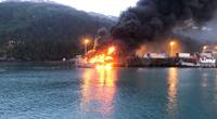 A fire burns at Delong Dock after an explosion on fixed barge in Whittier, Alaska, July 8, 2019. In addition to Coast Guard crews, response efforts included members of the Whittier Fire Department, Whittier Police Department, Anton Anderson Memorial Tunnel Fire Department and Girdwood Fire Department. Photo courtesy of Coast Guard Sector Anchorage.