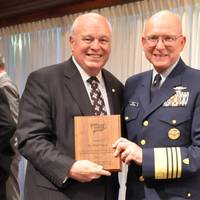 2012 photo of US Coast Guard Commandant Robert J. Papp, Jr. presenting AdvanFort President William H. Watson a plaque for service to the Amver program and Amver Logo