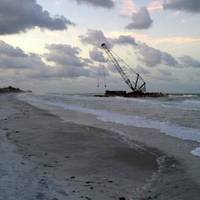 A 140-foot barge is shown beached on Long Boat Key, Fla., Wednesday, April 9, 2014. Due to weather conditions, the barge spuds were unable to hold the barge in position and it began drifting until it ran aground on the beach at Long Boat Key. (U.S. Coast Guard photo)