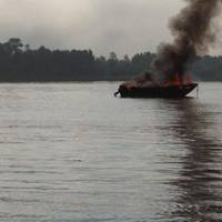 A 17-foot pleasure craft is fully engulfed in flames near Sugar Island on the St. Marys River, Aug. 29, 2013. U.S. Coast Guard photo by Petty Officer 1st Class Joseph Kerr, executive petty officer of Station Sault Ste. Marie.