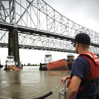 A Coast Guard crewmember aboard a 41-ft. smallboat from Coast Guard Station New Orleans overlooks the sunken barge in the Mississippi River in downtown New Orleans after the motor vessel Tintomara and a tub and barge collided early Wed. July 23, 2008 spilling approximately 419,000 gals. of number six fuel oil.  (U. S. Coast Guard photo/Petty Officer 2nd Class Thomas M. Blue)