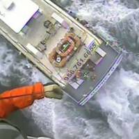 A Coast Guard rescue swimmer is lowered to the Osprey II and a man suffering from chest pains is hoisted back up Saturday near Port Mansfield, Texas. U.S. Coast Guard video by Air Station Corpus Christi.