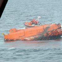 A crew from the Coast Guard Cutter Shearwater approaches a capsized lifeboat from the Bow Mariner. U.S. COAST GUARD PHOTO