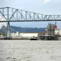 A pair of tugs support the 623-foot motor vessel Sparna under the Lewis and Clark Bridge while transiting to a pier in Kalama,Wash., March 23, 2016. A small boat crew from Coast Guard Station Portland also escorted the Sparna enforcing a 100-yard safety zone. (U.S. Coast Guard photo by Levi Read.)
