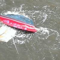 A personal craft is capsized after a collision with a tug and barge Sunday. U.S. Coast Guard photo.