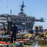A sailor looks at firefighting gear laid out in front of the amphibious assault ship USS Bonhomme Richard (LHD 6). (U.S. Navy Photo by Natalie M. Byers)