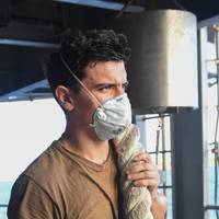 A U.S. Navy Seaman holds onto mooring line on the fantail of the aircraft carrier USS Theodore Roosevelt as the ship departs Apra Harbor May 21, 2020, after being sidelined in Guam due to a COVID-19 outbreak on board. (U.S. Navy photo by Erik Melgar)