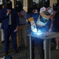 A welder from Thoma-Sea Marine Constructors, LLC, welds the initials of the Oceanographer's sponsor, Linda Kwok Schatz, wife of U.S. Sen. Brian Schatz of Hawaii, onto a steel plate that will be incorporated into the ship. (Photo: NOAA)