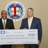 Brian Cuccias (right), president of Ingalls Shipbuilding, presents a check for $89,786.90 to James Lowe Jr., president of Bishop State Community College. The money will be used to purchase 20 welding machines and wire feeder boxes for the school’s welding technology program. Photo by Lance Davis/HII