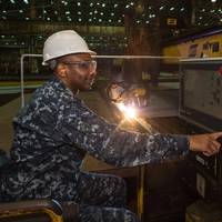 Cmdr. Dave Murray, post-delivery officer for the U.S. Navy’s DDG 51 program, presses the button to start fabrication of the Ingalls-built destroyer Frank E. Petersen Jr. (DDG 121). Photo by Lance Davis/HII